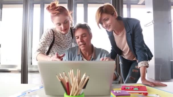 Diretor criativo olhando para laptop com equipe — Vídeo de Stock