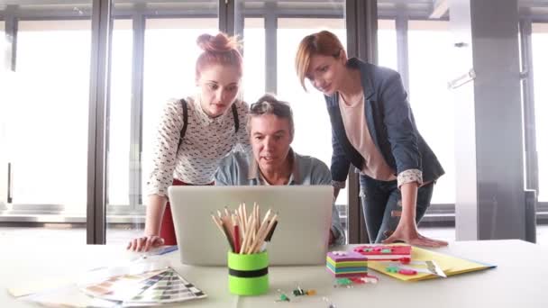 Kreativdirektor schaut mit Team auf Laptop — Stockvideo