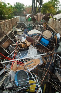 Kamyon şoförü avluya geri dönüşüm çöp toplamak için vinç yardımıyla.