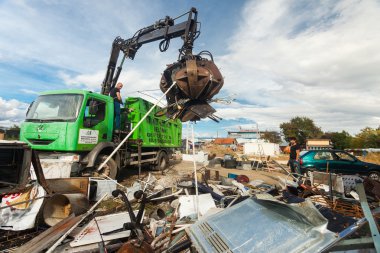 Kamyon şoförü çöp toplamak için vinç yardımıyla