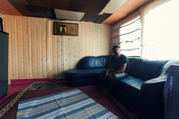 Man sitting on a couch — Stock Photo, Image