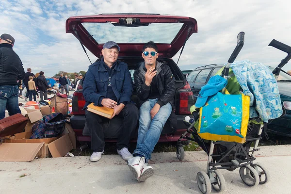 Roma man sitting at the car trunk — Stock Photo, Image