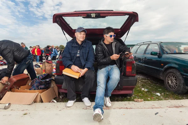 Roma man zit op de auto kofferbak — Stockfoto