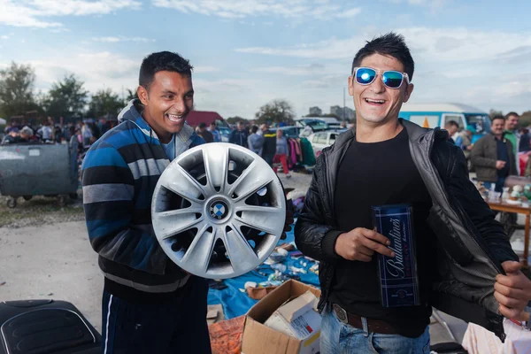 Salesmen holding used car rim — Stock Photo, Image