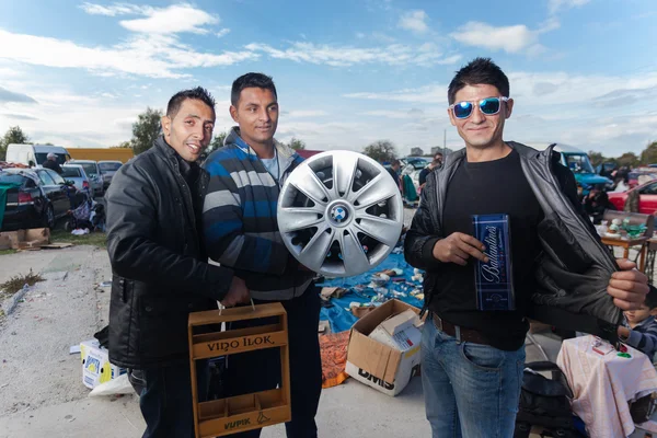 Salesmen holding used car rim — Stock Photo, Image