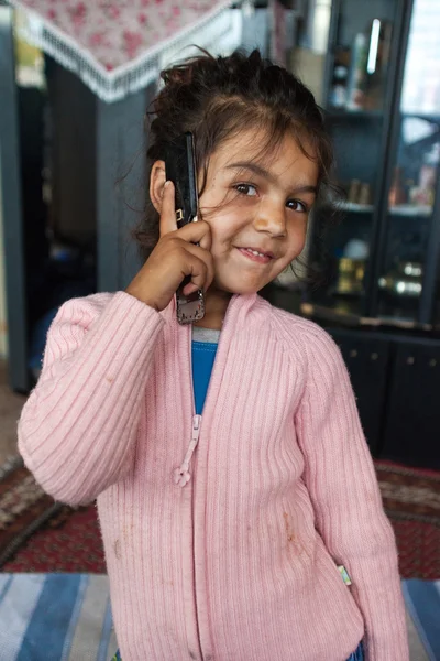 Chica romaní sosteniendo teléfono móvil — Foto de Stock