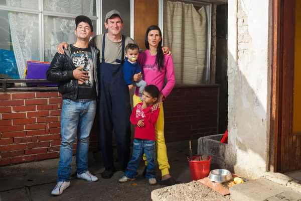 Rodina pózuje před domem — Stock fotografie