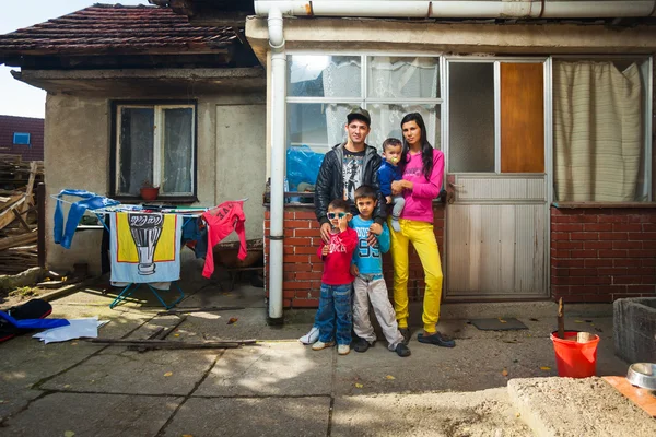 Rodina pózuje před domem — Stock fotografie