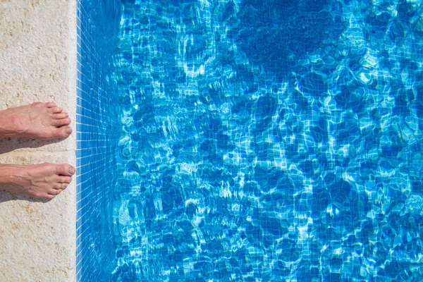 Par de pés em pé na frente da piscina — Fotografia de Stock