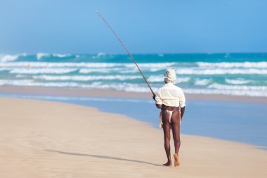 Elderly stilt fisherman at Hikkaduwa Beach. clipart