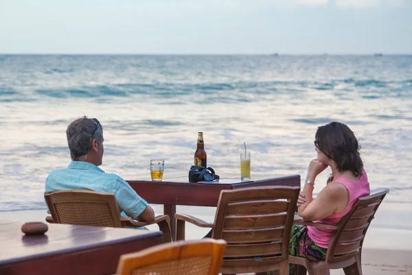 Pareja de turistas tomando trago en el bar de la playa — Stock fotografie