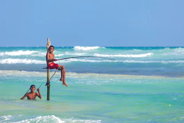 Jovens pescadores de palafitas em Hikkaduwa Beach . — Fotografia de Stock