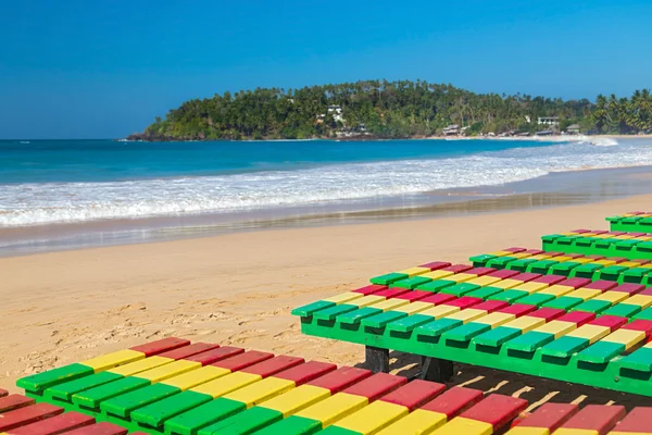 Kleurrijke houten ligstoelen op unawatuna strand in sri lanka. — Stockfoto