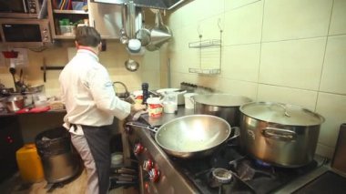 Şef mutfakta yemek pişiriyor.