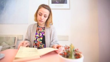 Bir kafede menüyü okuyan kadın