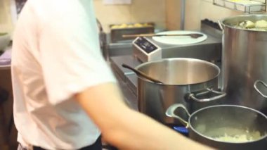 Şef mutfakta yemek pişiriyor.