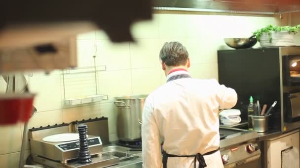 Chef-koks koken in de keuken van het restaurant — Stockvideo