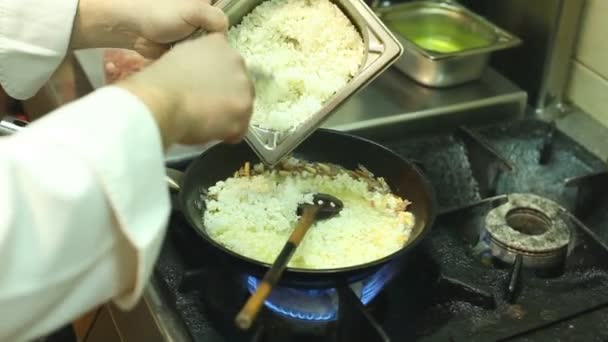 Chef ajoutant des ingradients dans une poêle chaude — Video