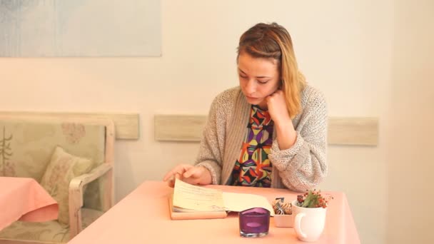 Frau liest Speisekarte in einem Café — Stockvideo