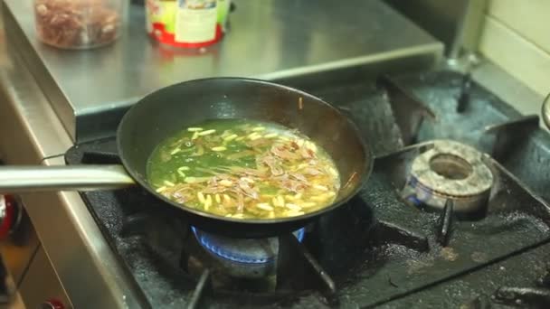 Шеф-повар добавляет масло в горячую сковороду — стоковое видео