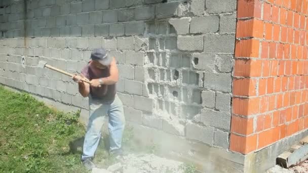 Trabajador derribando pared de la casa — Vídeo de stock