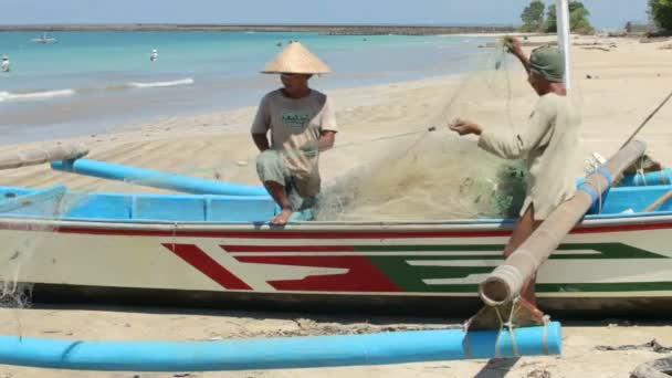 Vissers schoonmaken netten op strand — Stockvideo