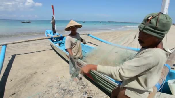 Fiskare rengöring nät på stranden — Stockvideo