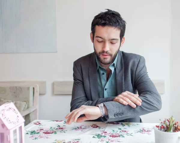 Man in restaurant looking at watch — Stock Photo, Image