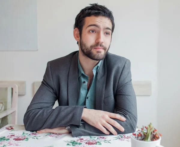 Young man sitting in restaurant — Stock Photo, Image