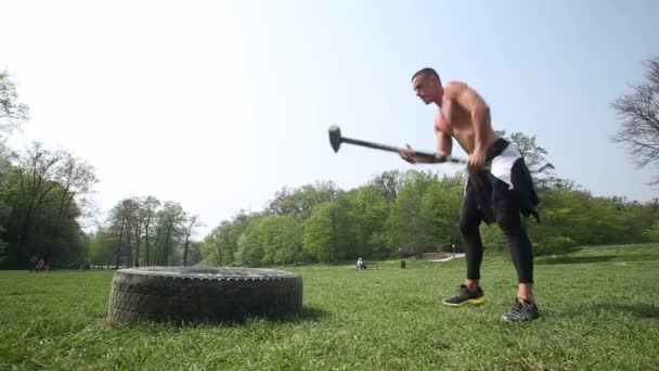 Homme frappant pneu avec marteau — Video