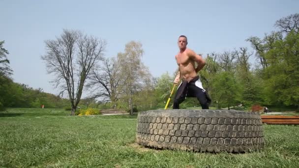 Mann schlägt mit Hammer auf Reifen ein — Stockvideo