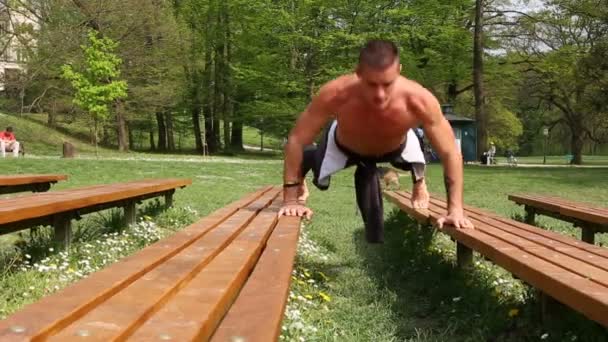 Człowiek robi pompki na ławce — Wideo stockowe