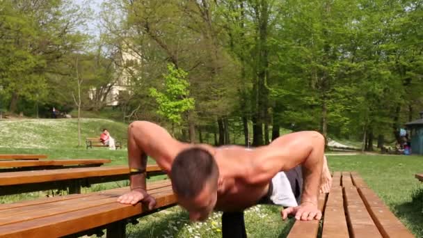Muž dělá kliky na lavičce — Stock video