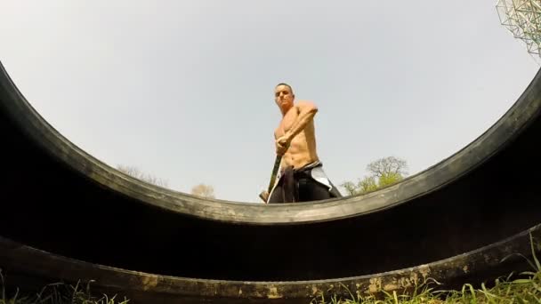 Hombre golpeando neumático con martillo — Vídeo de stock
