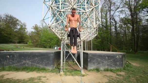 Hombre haciendo pull-ups en anillos de gimnasia — Vídeo de stock