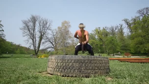 Homem batendo pneu com martelo — Vídeo de Stock