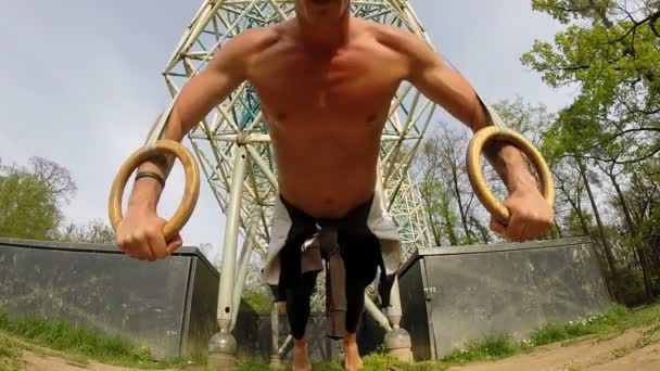 Мужчина отжимается на кольцах для гимнастики — стоковое видео