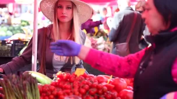 Ung kvinna pratar på marknaden — Stockvideo