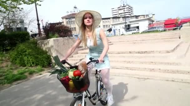 Menina andar de bicicleta com cesta cheia de frutas — Vídeo de Stock