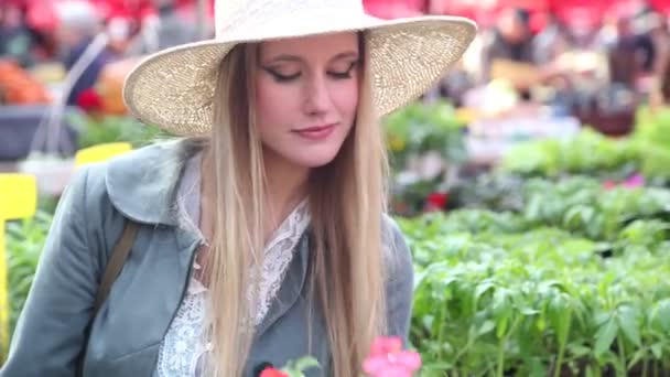 Fille sentant les fleurs au marché — Video