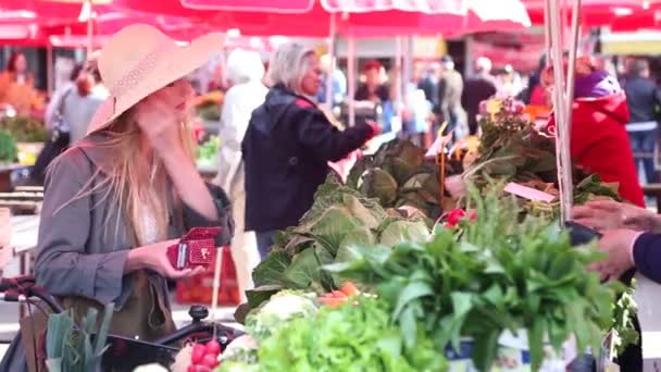 Flicka på marknaden betalar för Rädisa — Stockvideo