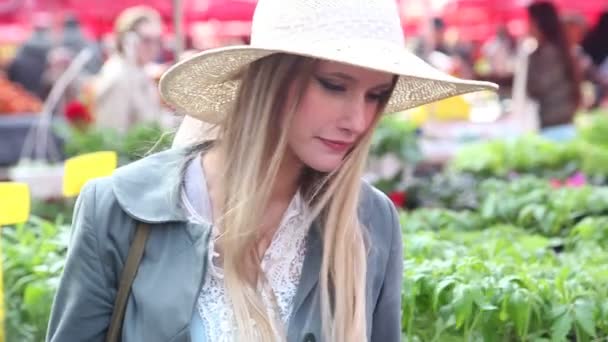 Chica oliendo flores en el mercado — Vídeo de stock