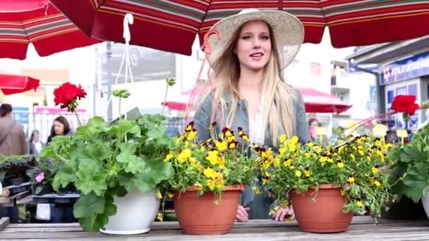Красивая девушка разговаривает на рынке — стоковое видео