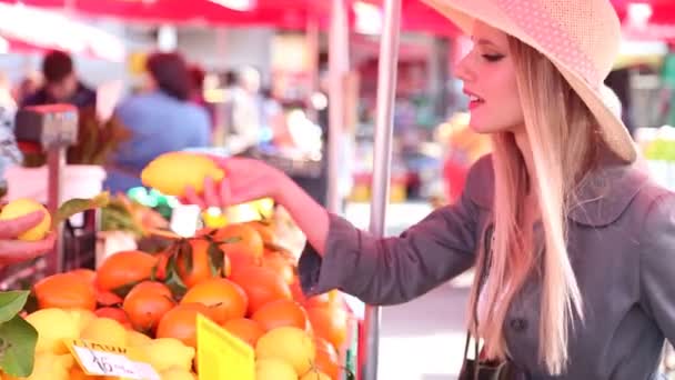 Meisje op de markt plukken van citroenen — Stockvideo