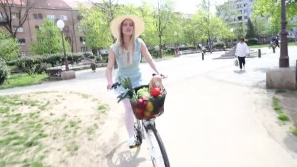 Девушка на велосипеде с шляпой — стоковое видео