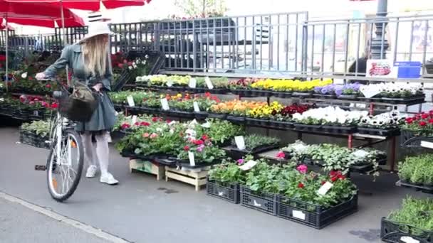 Dívka na kole na trhu s květinami