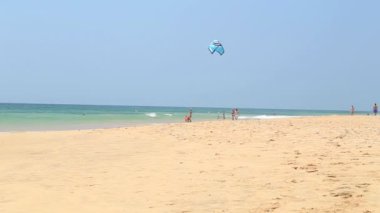 Adam uçurtma ile kumsalda oynarken