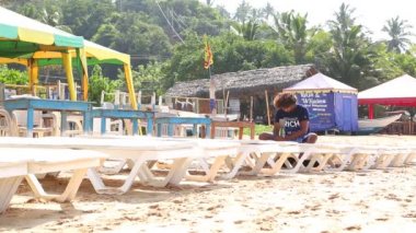 Adam şezlong turistler için hazırlanıyor