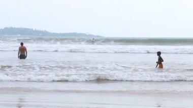 Weligama okyanusta dalgaları zevk insanlarla görünümünü
