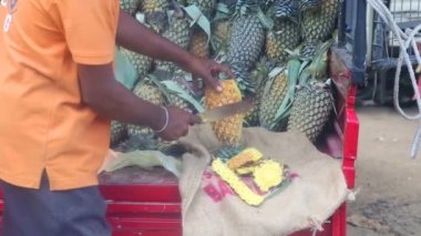 Yerel adam bir ananas Hikkaduwa markette Dilimleme.